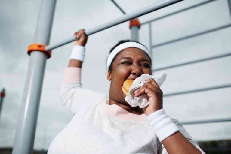 barfiks çekerken hamburger yiyen kadın